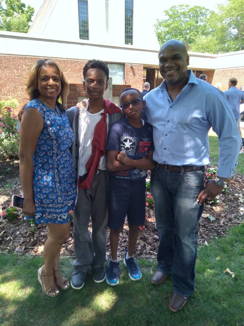 A family posing for a picture in the yard.