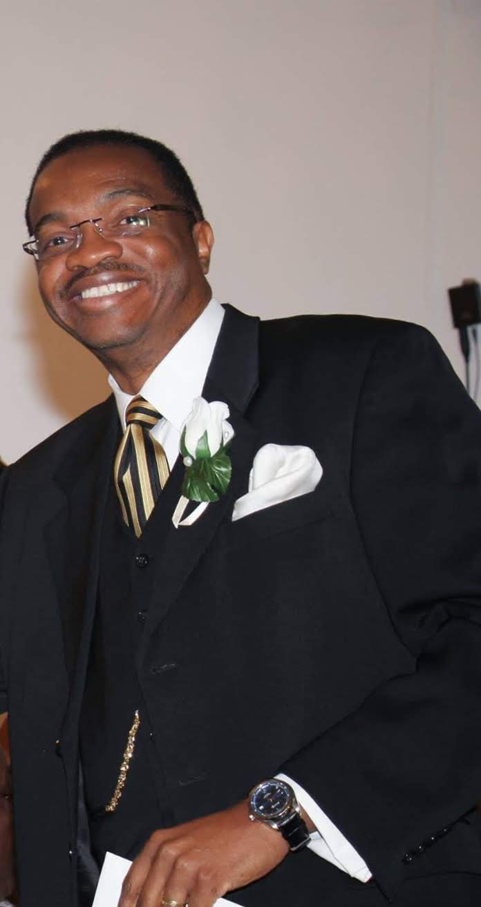 A man in a suit and tie smiling for the camera.