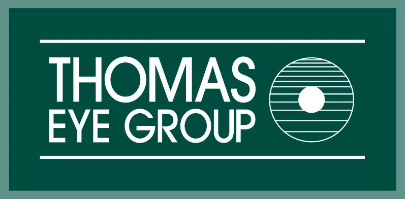 A green sign with white lettering that says thomas the group.