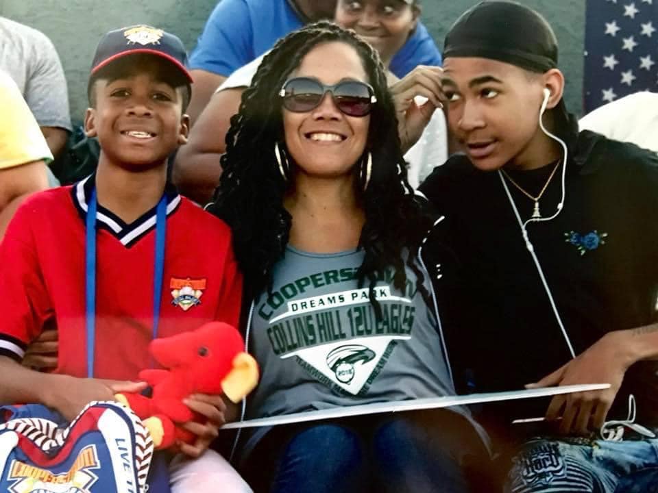 A woman and two boys are sitting together.