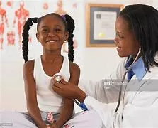 A doctor examining a young girl 's lungs.
