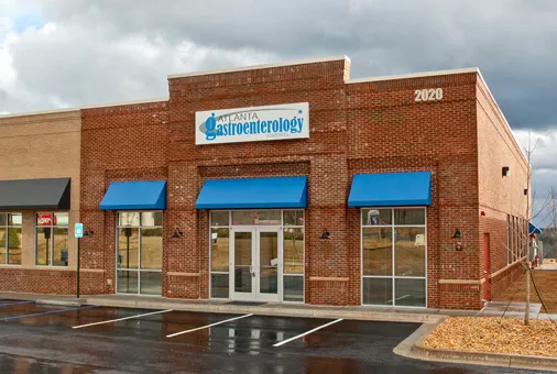 A large brick building with blue awnings on the front.