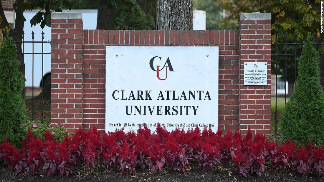 A sign for clark atlanta university on the side of a brick wall.