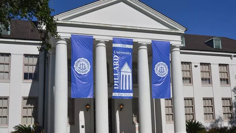 A building with columns and three banners hanging from it.