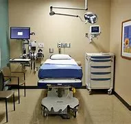 A hospital room with a bed and some chairs