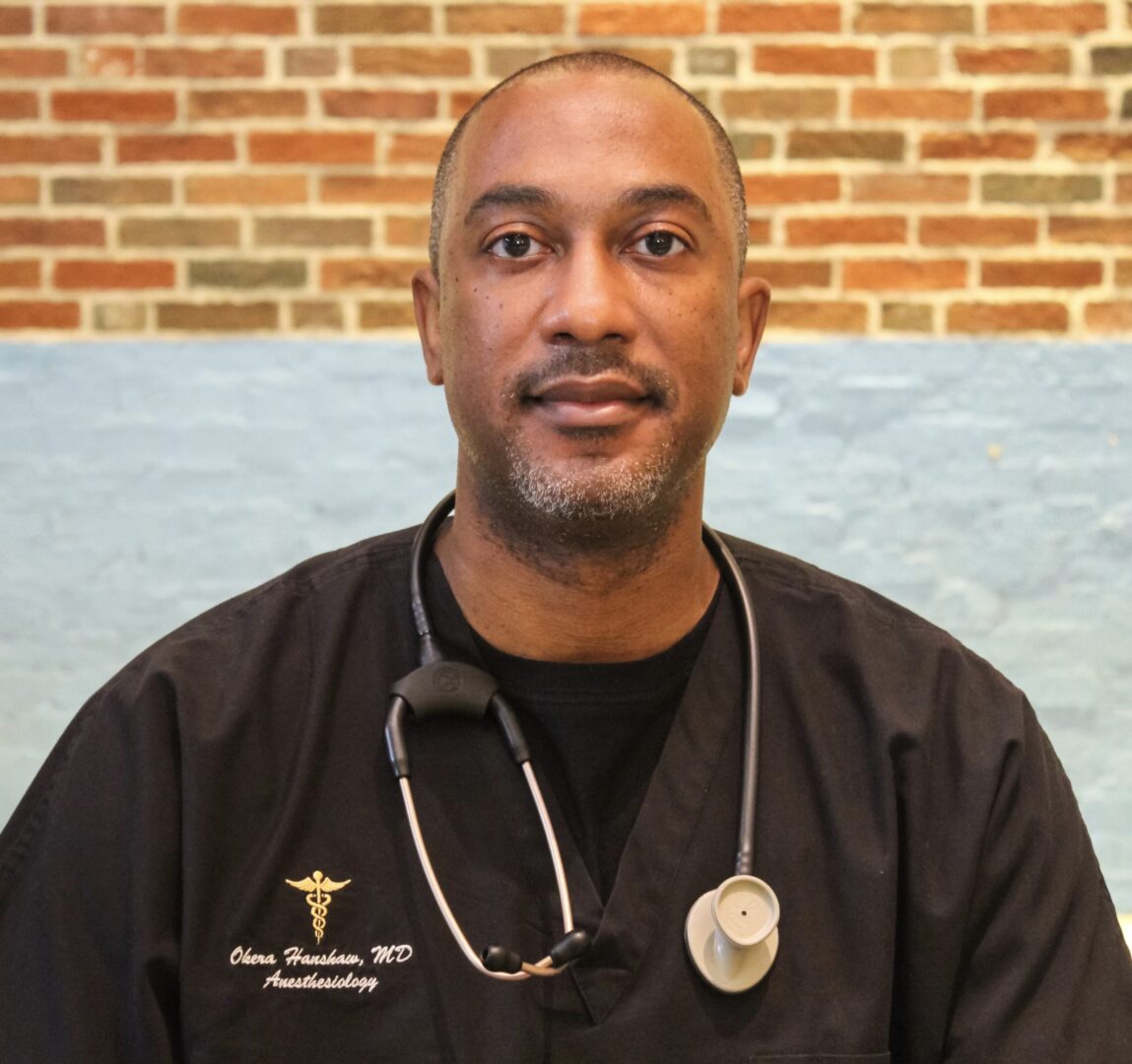 A male doctor wearing black scrubs and stethoscope.
