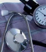 A stethoscope and a blood pressure monitor on top of a table.