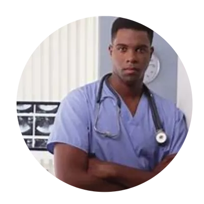 A male nurse in blue scrubs is standing with his arms crossed.