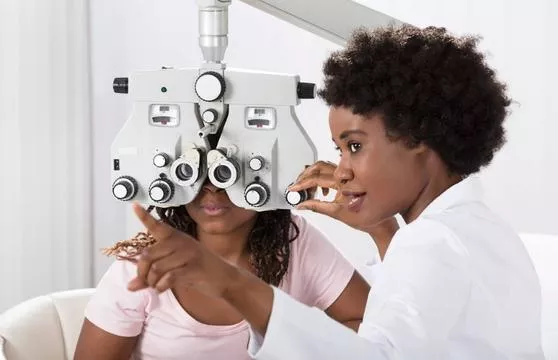 A woman getting her eyes checked by an eye doctor.