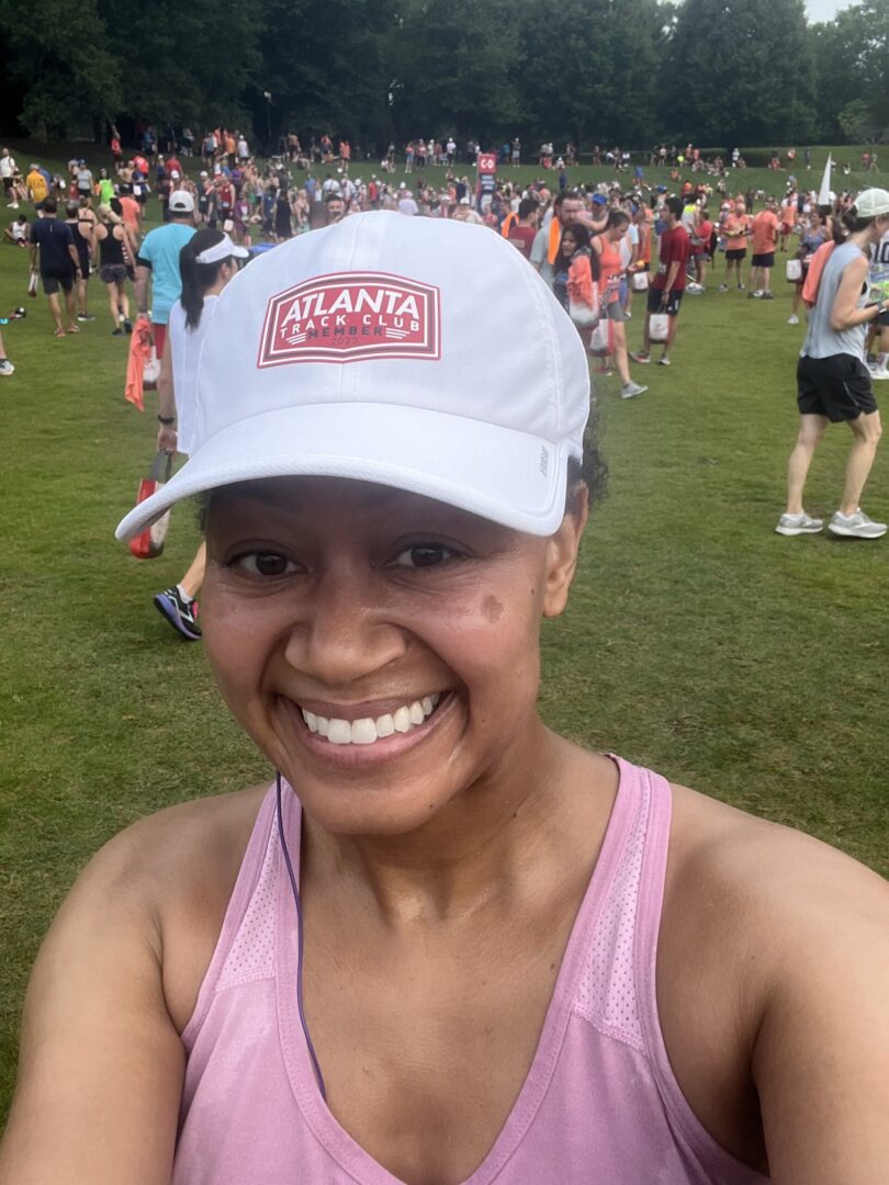 A woman wearing a hat standing in front of a crowd.
