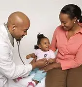 A doctor and nurse examining a child.