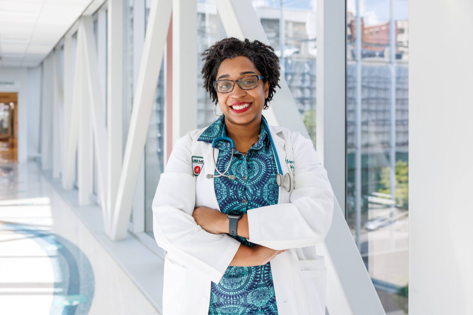 A woman in a white lab coat and blue skirt.