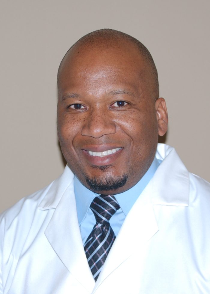 A man in white lab coat and tie.