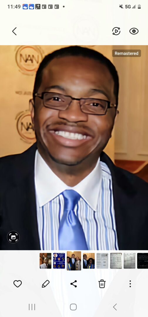 A man in a suit and tie smiling for the camera.