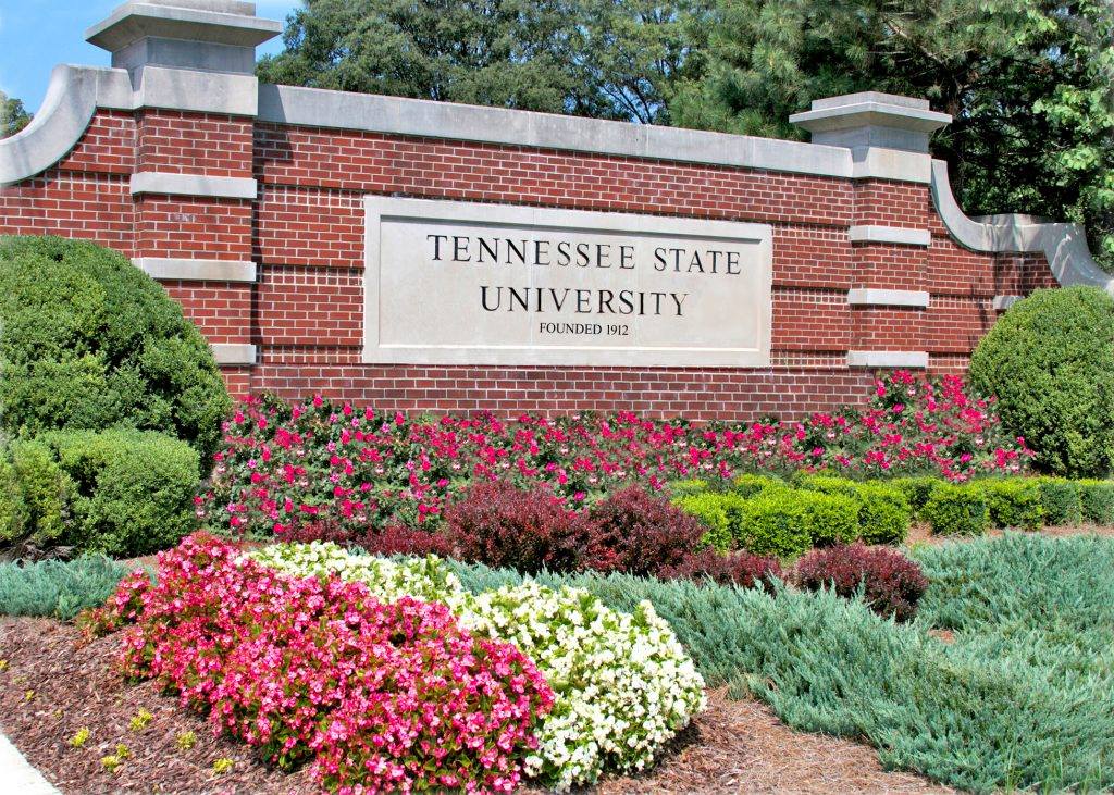 A sign that says tennessee state university surrounded by flowers.