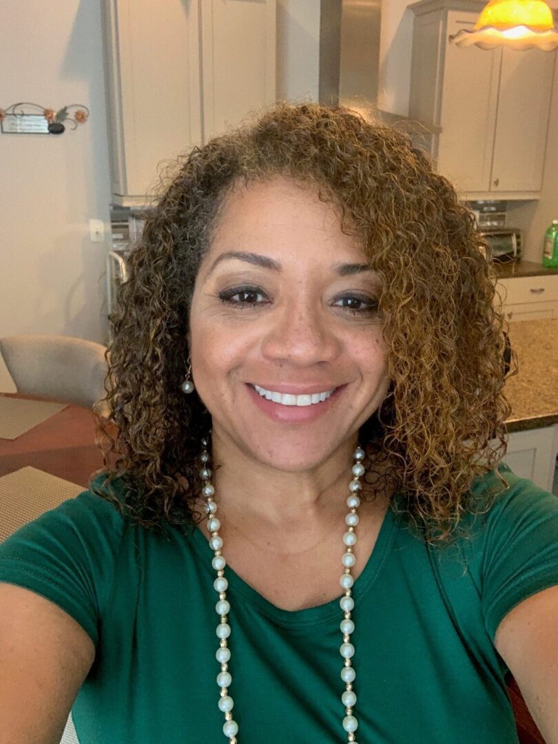 A woman with curly hair wearing a green shirt.