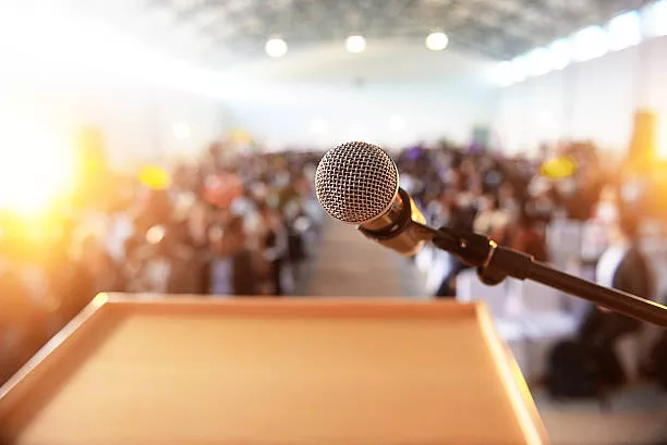 A microphone is pointed at the audience in front of it.