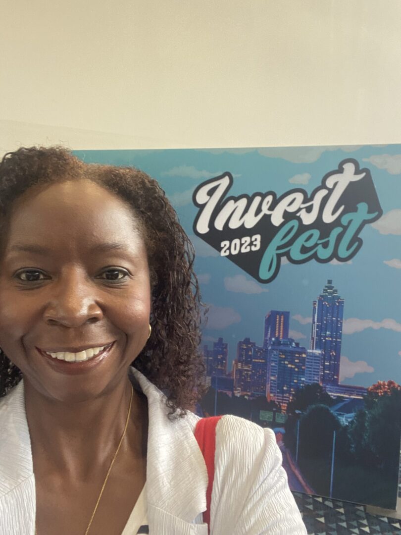 A woman standing in front of a sign that says invest fest.