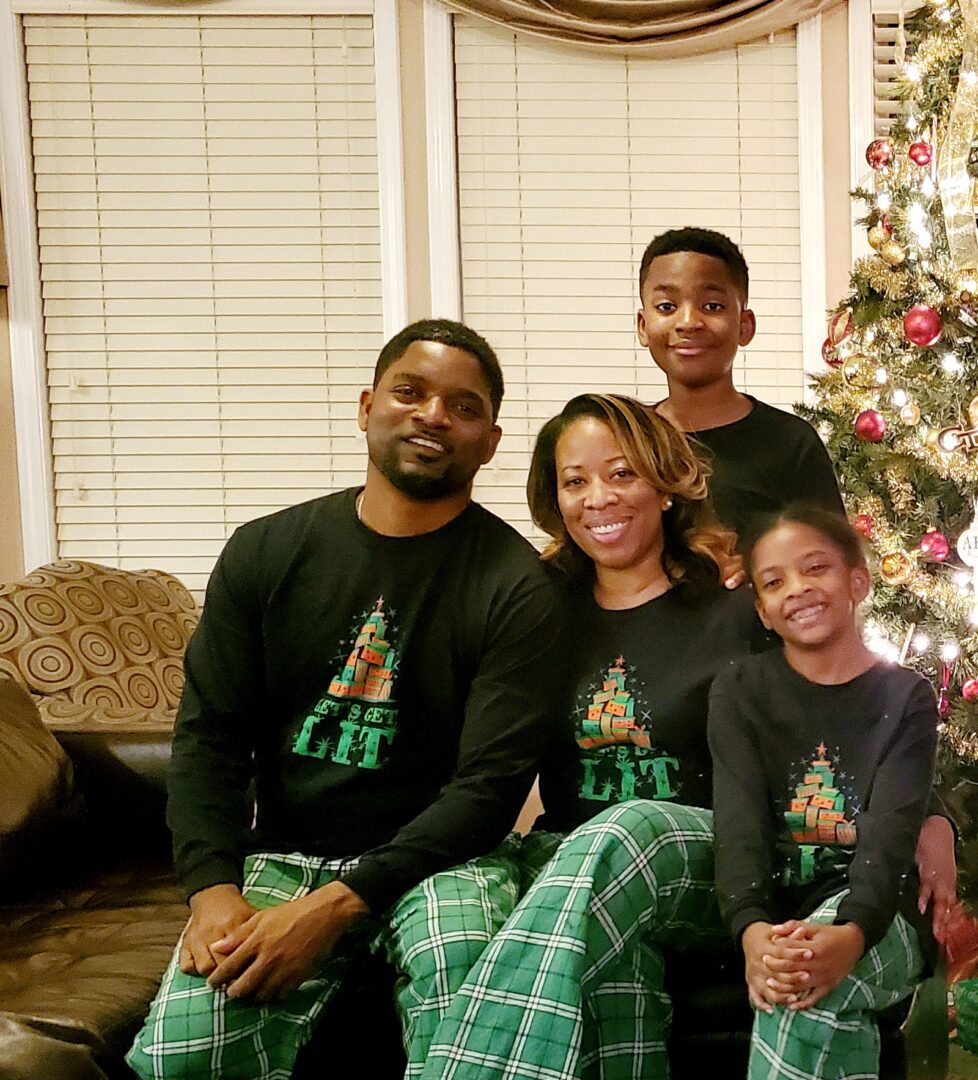 A family sitting in front of a christmas tree.