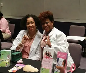 Two women sitting at a table with some books