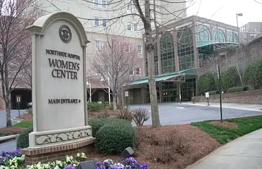 A women 's center sign in front of a building.