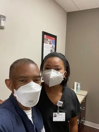 A man and woman wearing masks in an office.