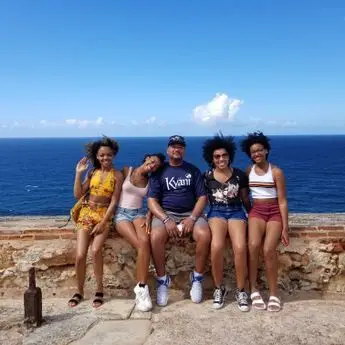 A group of people sitting on top of a rock wall.