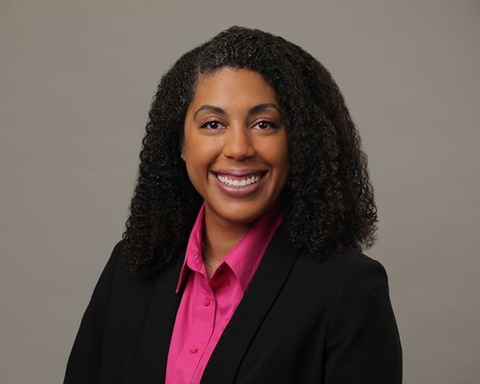 A woman in a pink shirt and black jacket