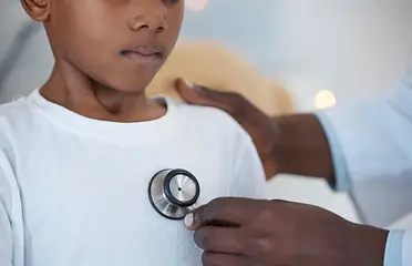 A person is holding a stethoscope on the chest of another person.