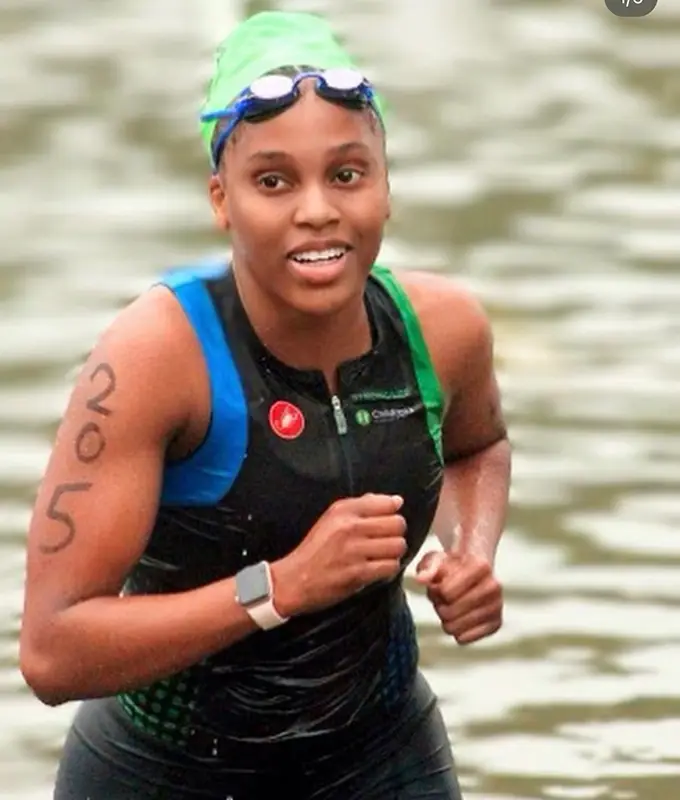 Woman in a swimsuit and goggles smiling.