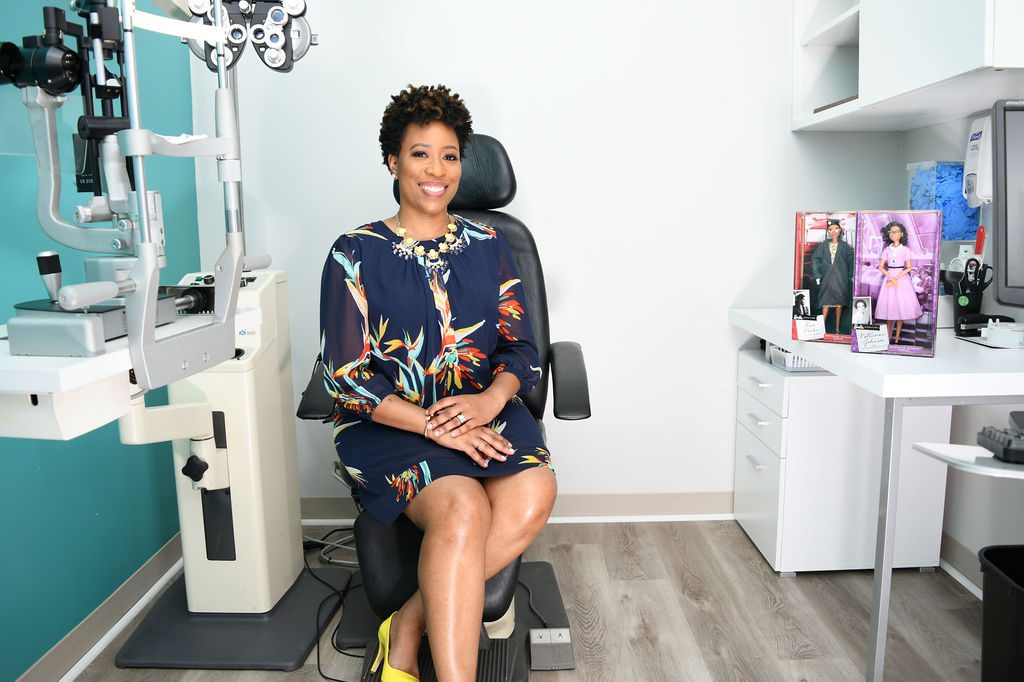 A woman sitting in an office chair smiling.