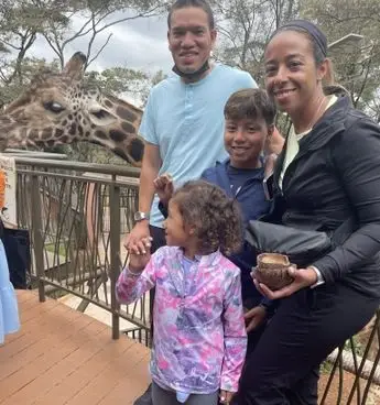 A family standing on the deck of a zoo