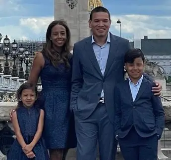 A family posing for a picture in front of the war memorial.