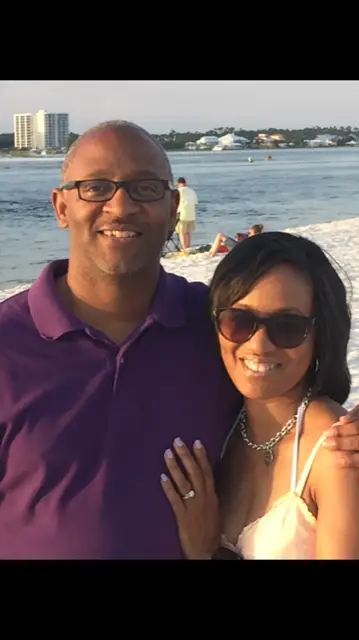 A man and woman standing on the beach.