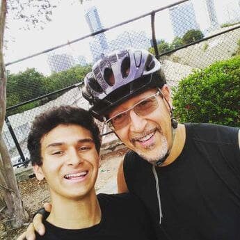 Two men posing for a picture with the city skyline in the background.