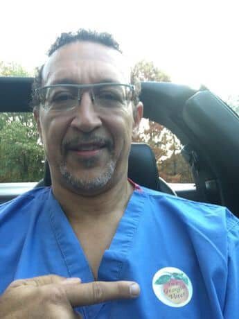 A man in blue shirt sitting inside of car.