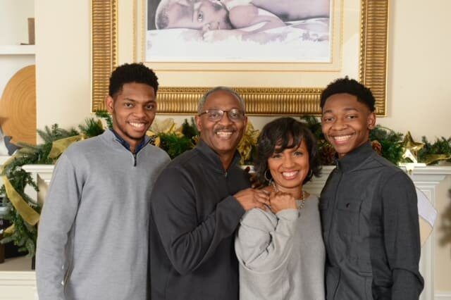 A family posing for the camera in front of a picture.
