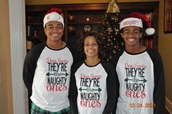 Three people wearing matching shirts and hats