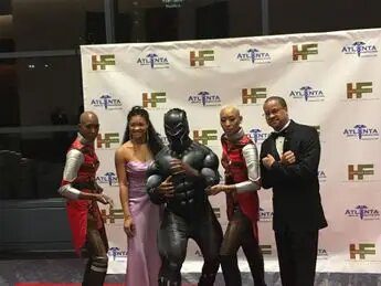 A group of people posing for a picture with a black man.