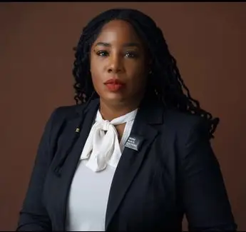 A woman in a suit and tie standing up.