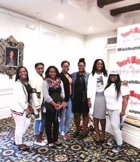 A group of women standing in front of a picture.