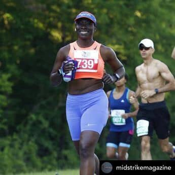 A woman running in the park while others watch.