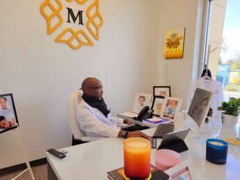 A man sitting at his desk in front of a laptop.
