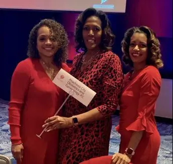 Three women in red are posing for a picture.
