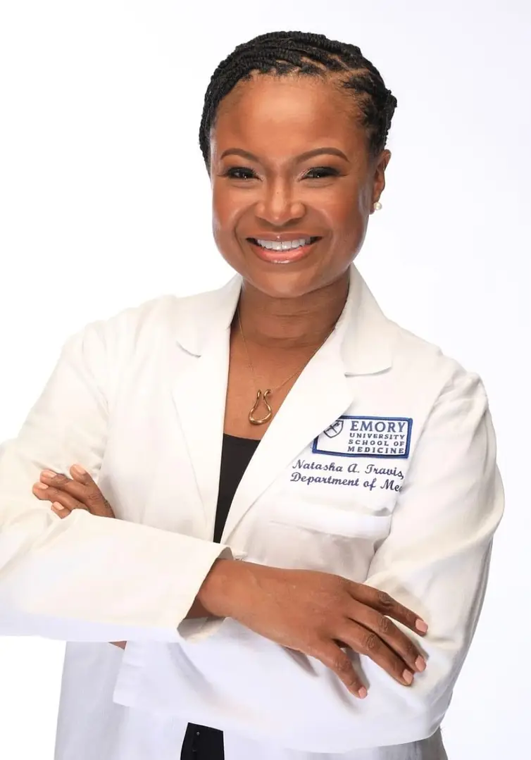 A woman in white lab coat with her arms crossed.
