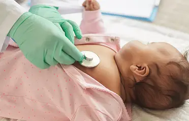 A person is using an electronic device to check the baby 's chest.