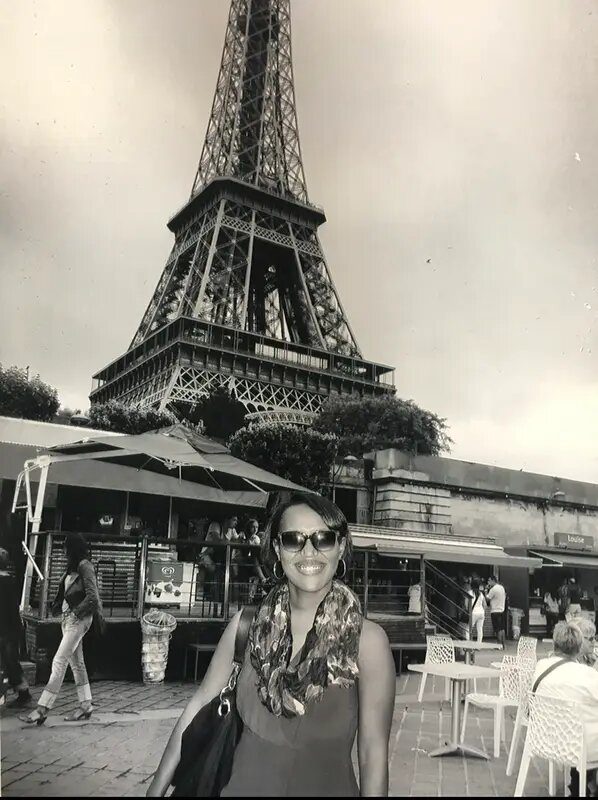 A woman standing in front of the eiffel tower.