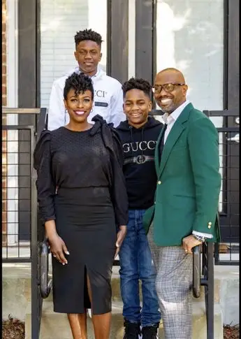 A family posing for a picture in front of some stairs.