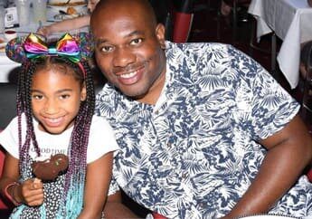 A man and young girl posing for the camera.