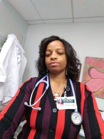 A woman in striped shirt with stethoscope around neck.
